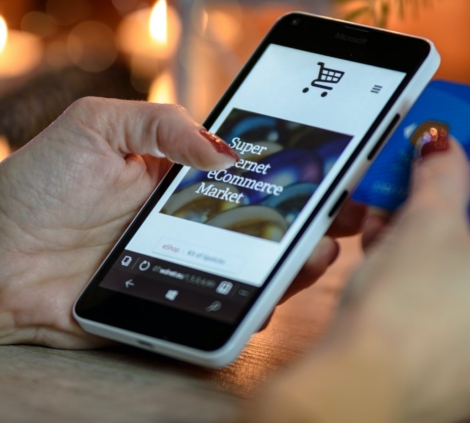 person using black and white smartphone and holding blue card